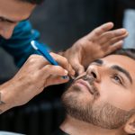 Hairdresser shaving client in barbershop Hairdresser shaving client in barbershop
